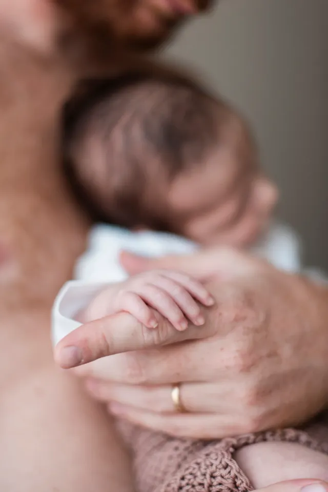Parent tenant son bébé endormi dans ses bras